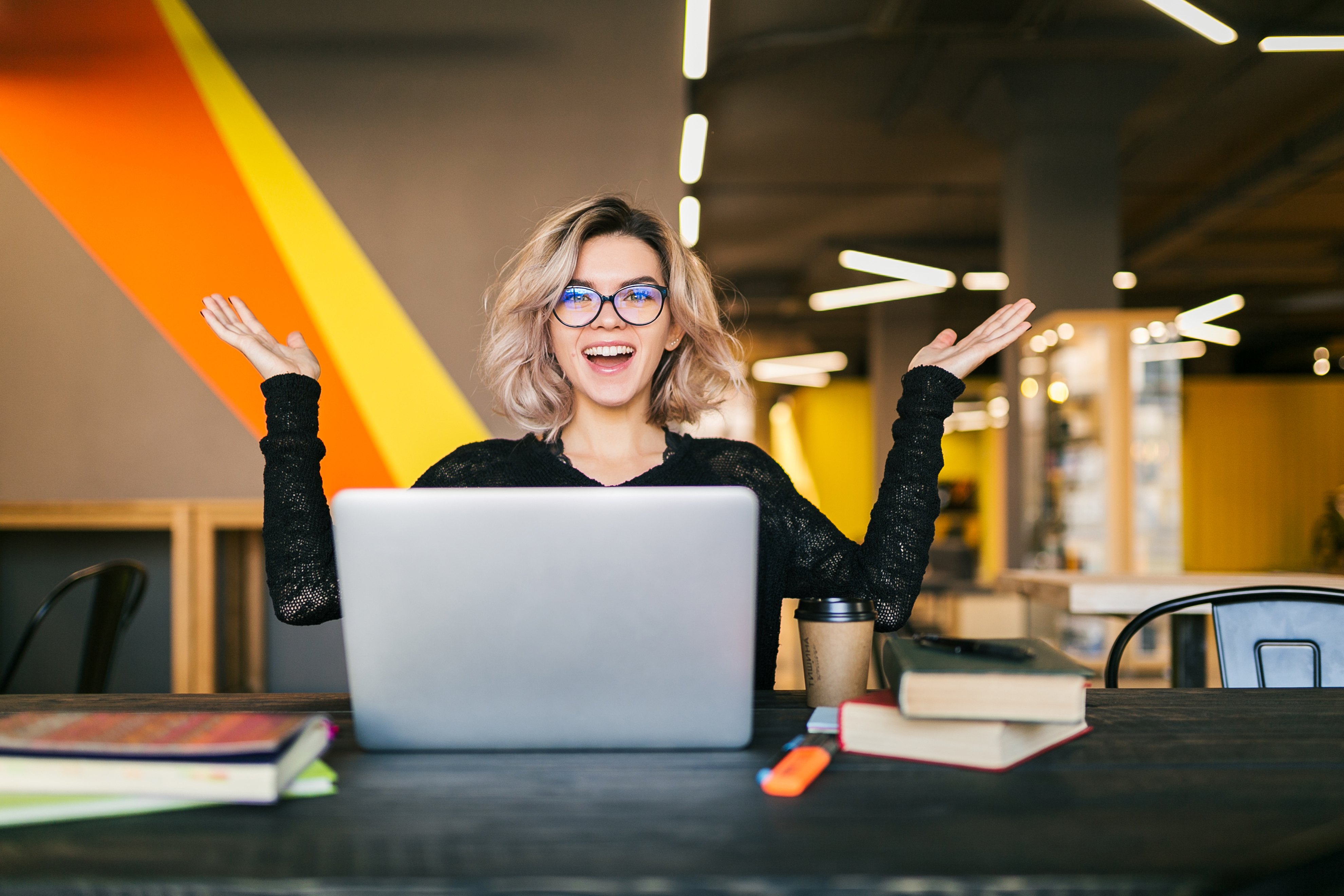 funny-happy-excited-young-pretty-woman-sitting-table-black-shirt-working-laptop-co-working-office-wearing-glasses.jpg